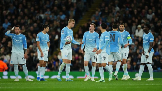 Manchester City players gather after conceding three first-half goals against PSG on 14 October 2026